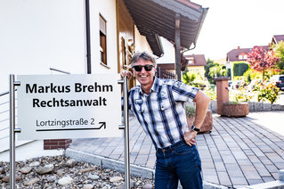 Rechtsanwalt Markus Brehm vor Schild
